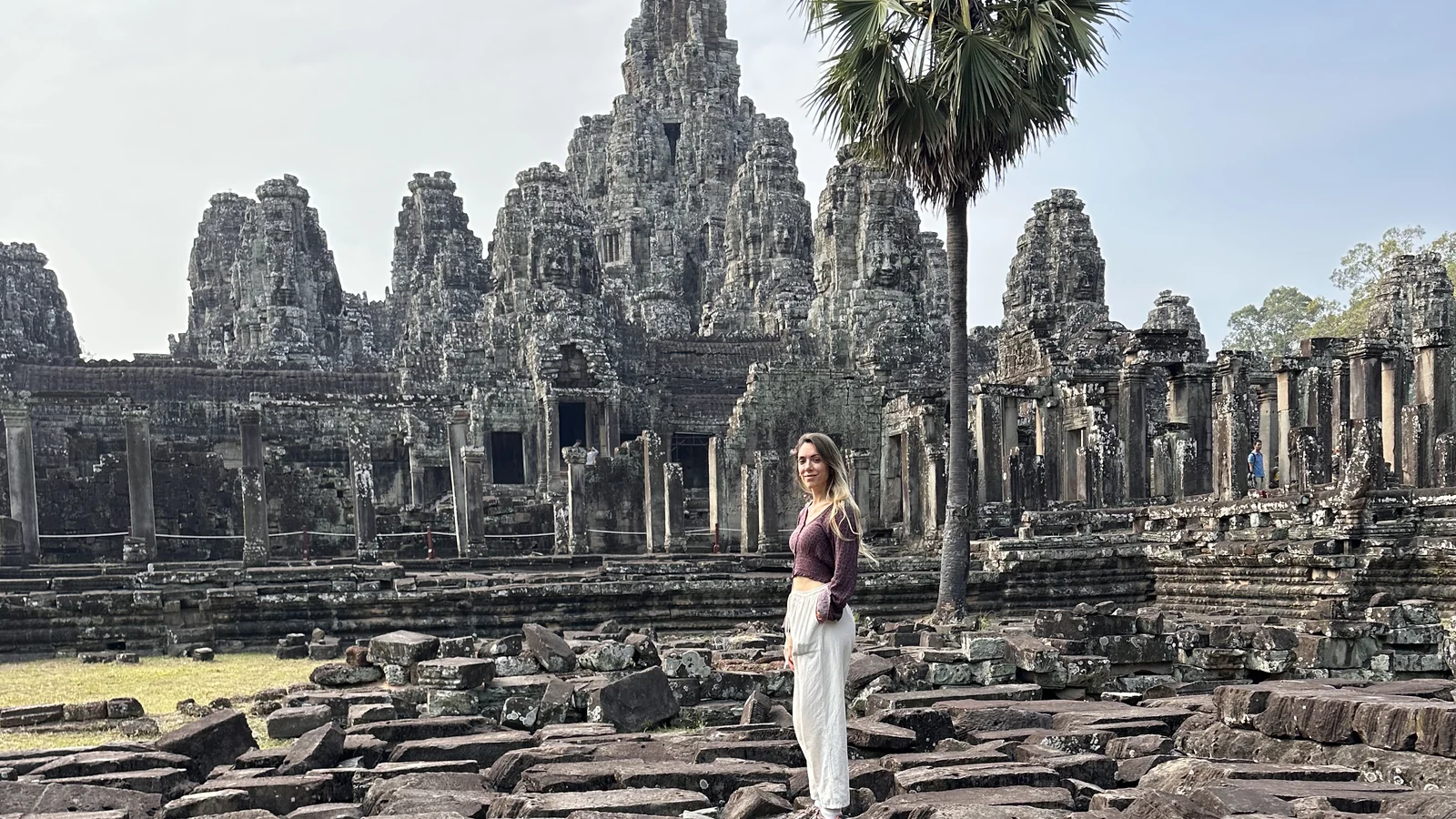 Le torri con i volti scolpiti del Bayon viste dalle pietre crollate del cortile