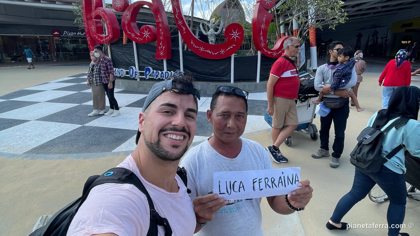 Luca all'aeroporto di Bali con l'autista che lo aspetta con il cartello, nel 2022