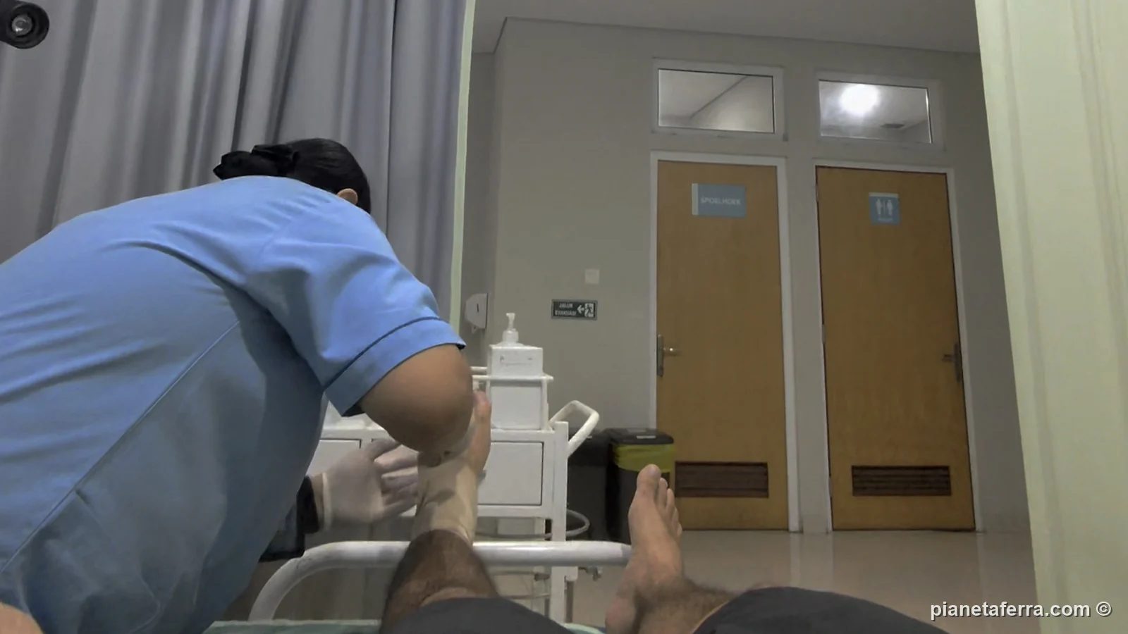 Un'infermiera medica il piede di Luca in una clinica di Bali dopo la caduta in scooter, all'inizio del 2026