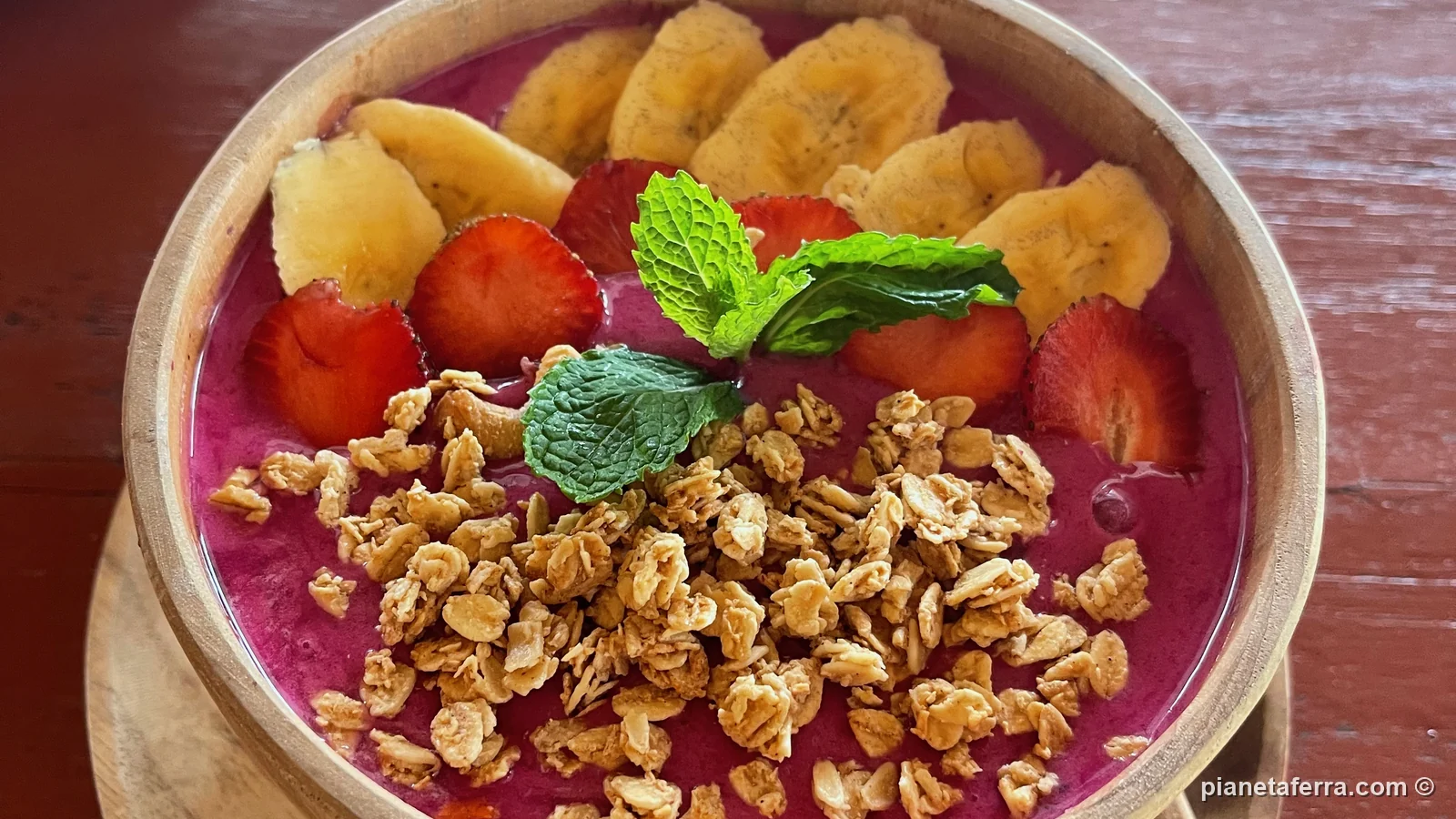 Smoothie bowl con banana, fragole e granola in un caffè di Bali