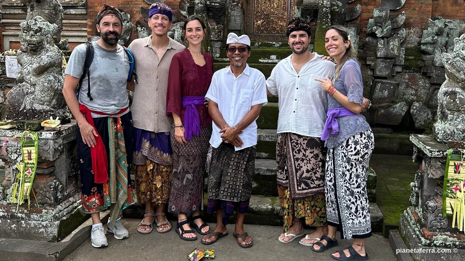 Gruppo di viaggiatori in abiti tradizionali balinesi al tempio con Sami