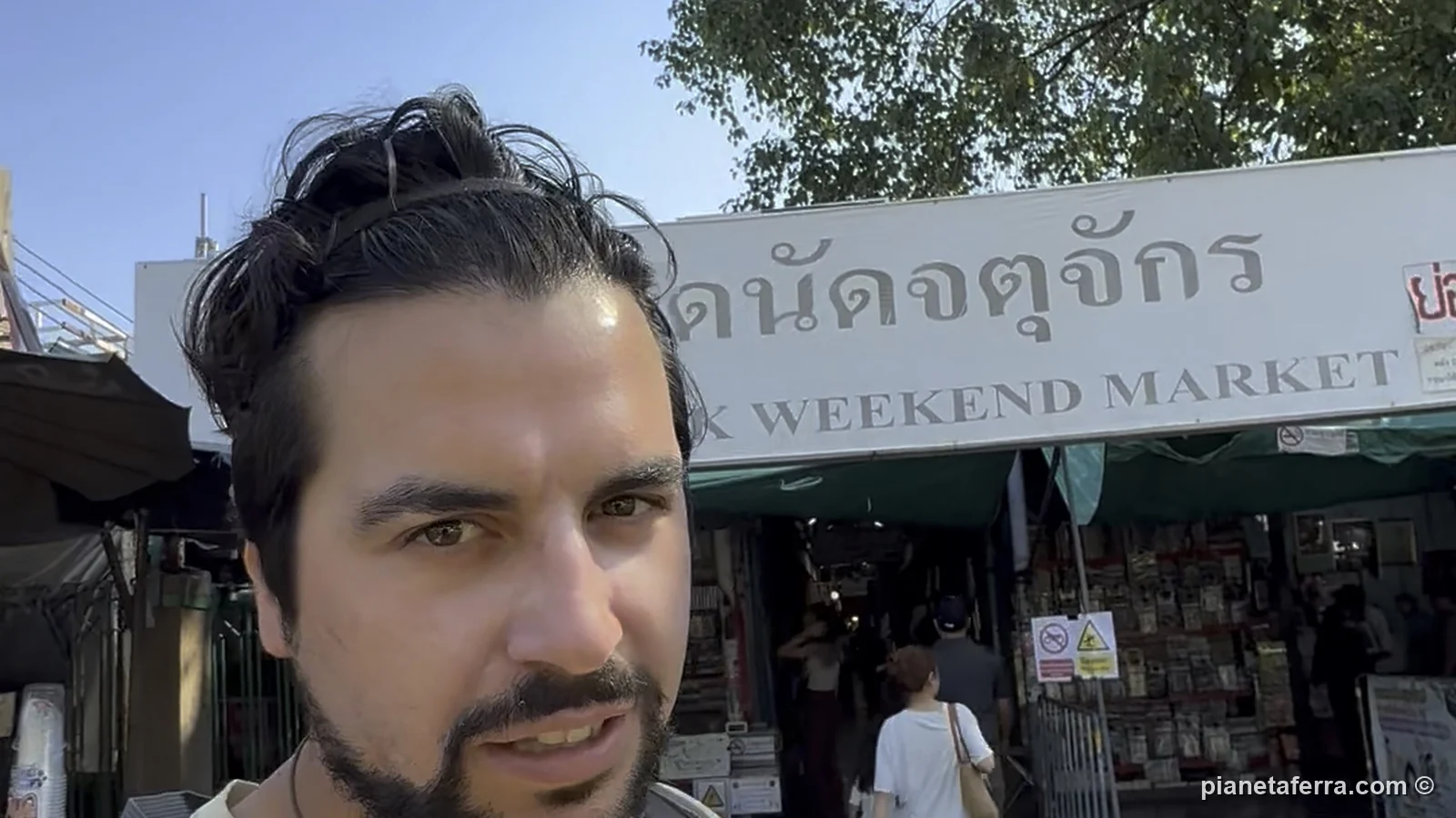 Luca davanti a uno degli ingressi del Chatuchak Weekend Market di Bangkok, con l'insegna in thailandese e in inglese