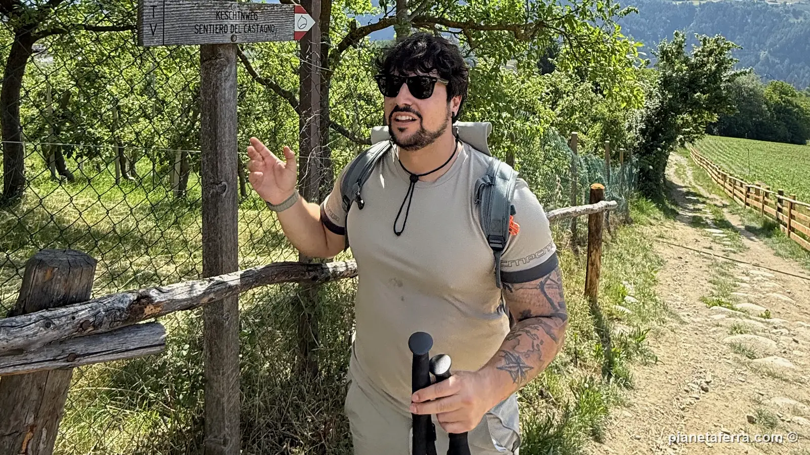 Luca con i bastoncini da trekking accanto al cartello del Sentiero del Castagno, in Valle Isarco, a fine maggio 2026