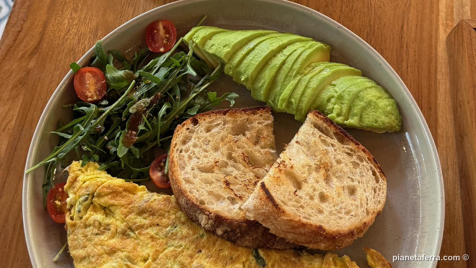 Colazione con omelette, avocado, rucola e pane tostato al Traveller Espresso di Ubud