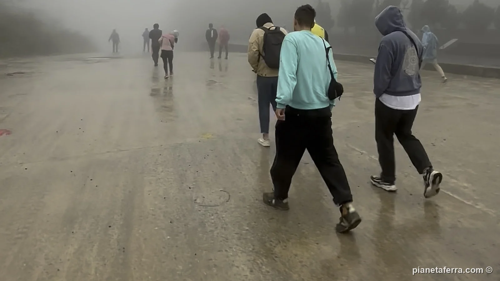Viaggiatori a piedi nella nebbia all'alba alla frontiera tra Vietnam e Laos di Cau Treo