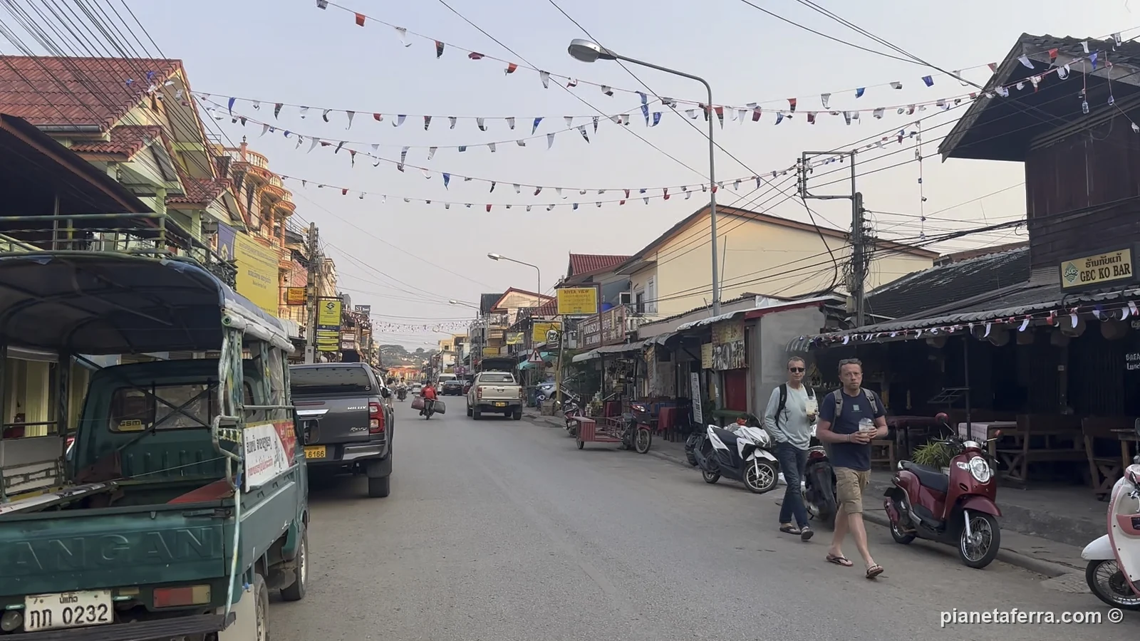 La strada principale di Huay Xai, sul Mekong, con i pick-up e le bandierine