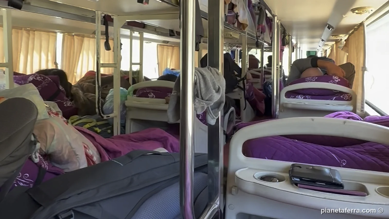 L'interno dello sleeping bus da Hanoi a Vientiane, con le cuccette su due piani e le coperte viola