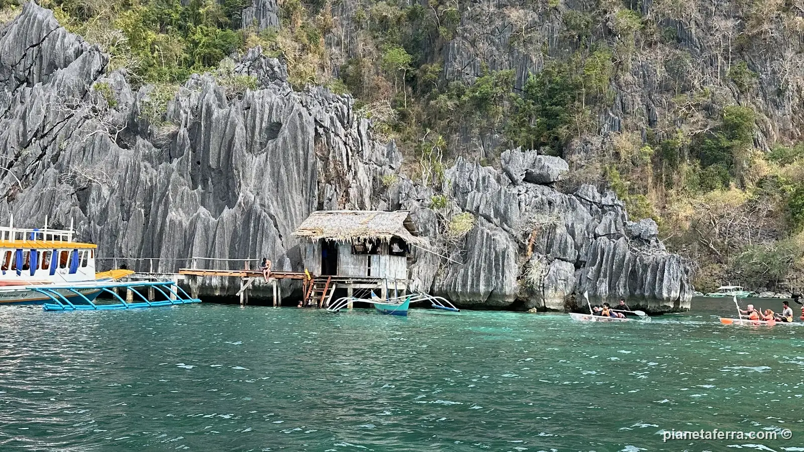 Le pareti di roccia calcarea e una palafitta all'ingresso di una laguna di Coron Island, nel 2024