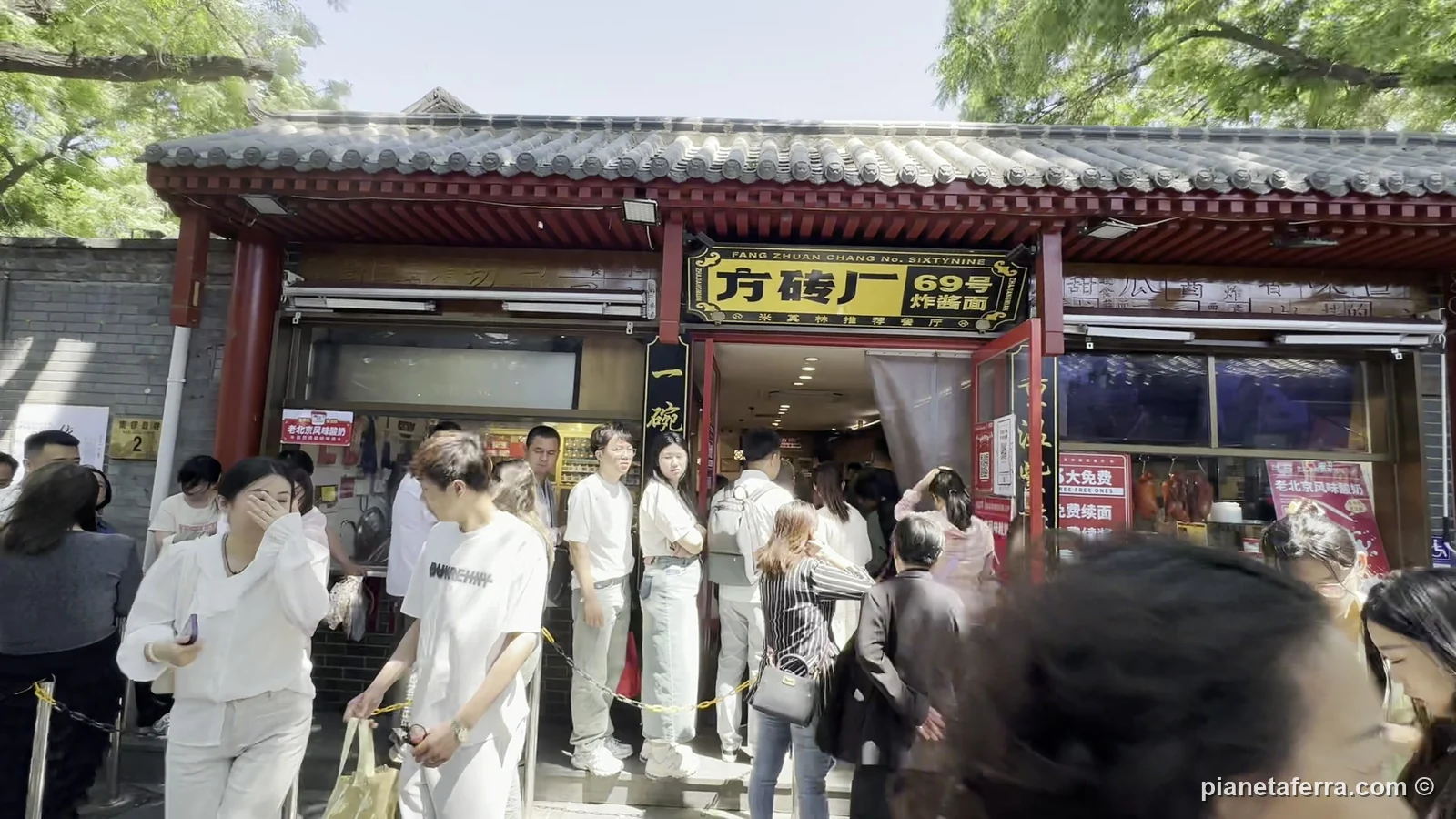 La coda davanti a un locale di noodles negli hutong di Nanluoguxiang, a Pechino, a maggio 2024
