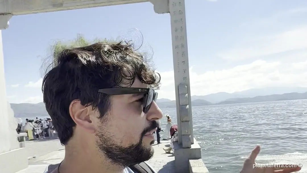Luca sul molo del lago Erhai, a Dali, con il lago mosso dal vento alle spalle