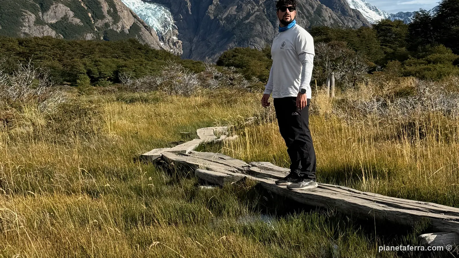 Luca su una passerella di legno tra l'erba gialla sul sentiero del ritorno dalla Laguna de los Tres