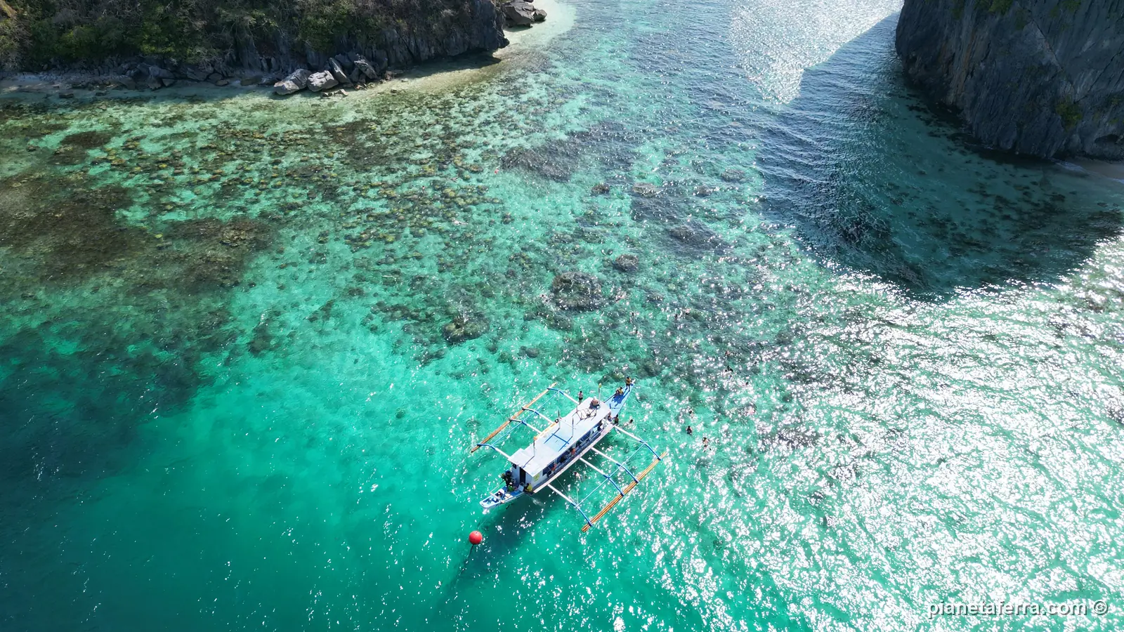 Una barca a bilanciere ferma sopra la barriera corallina tra le rocce del Tour C, vista dal drone, nel 2024