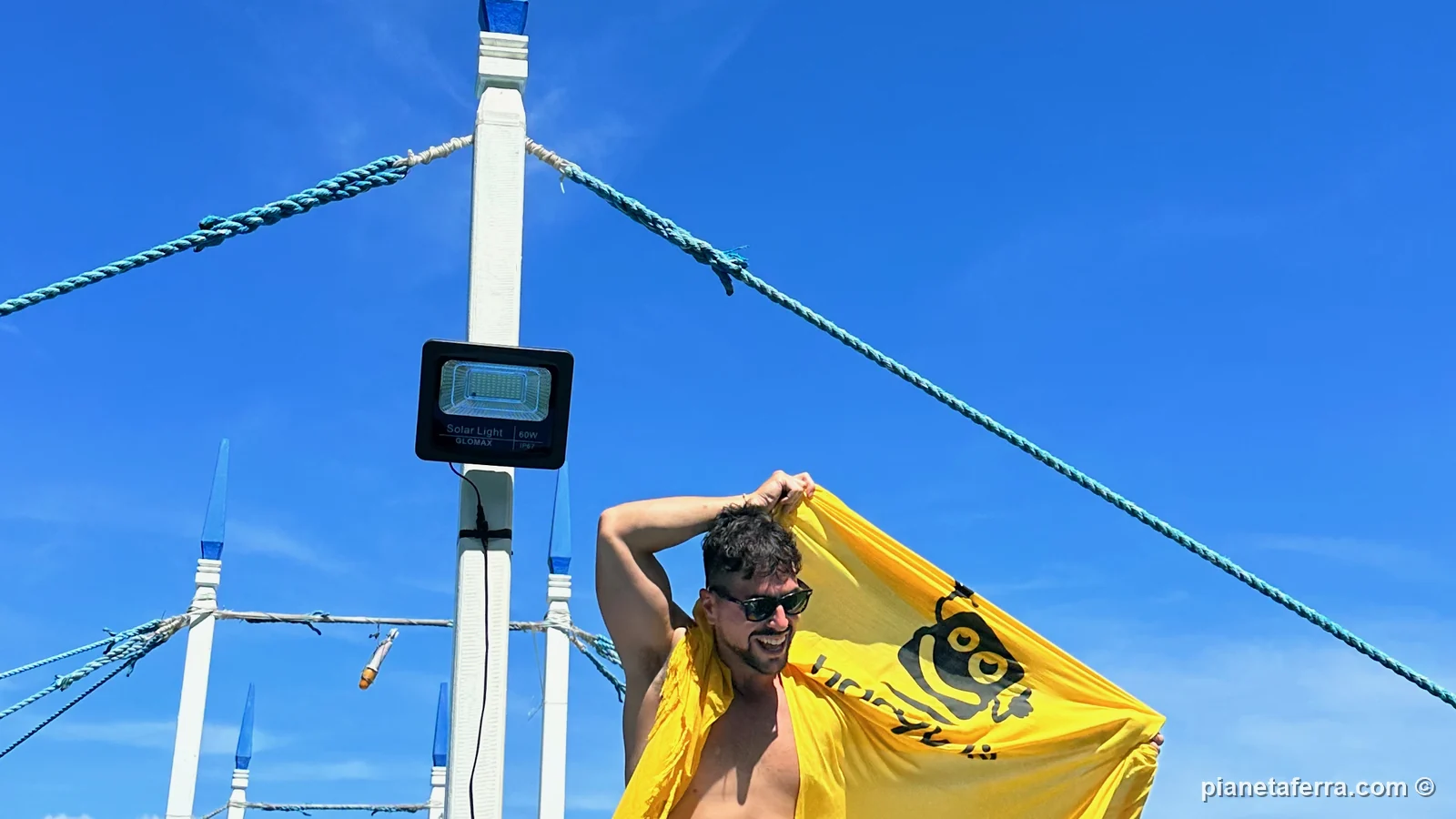Luca con la bandiera di Haqqy Life sulla barca di un island hopping a El Nido, nel 2023