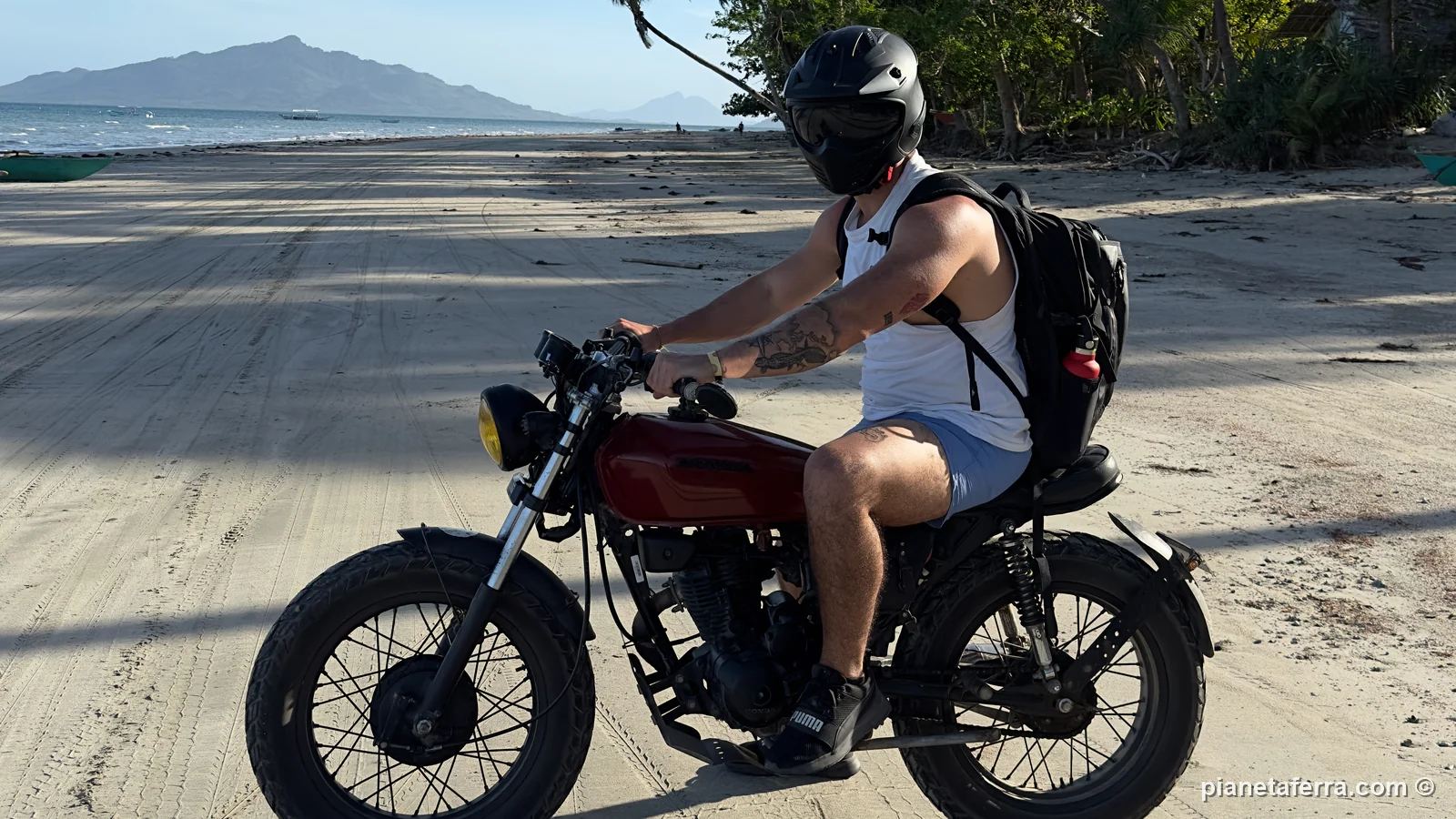 Luca in moto su una spiaggia deserta della costa di El Nido, nel 2023