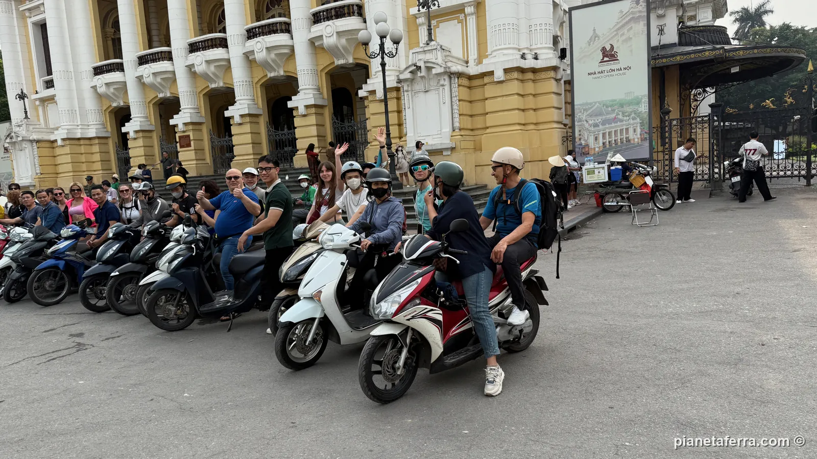Il gruppo in motorino davanti al Teatro dell'Opera di Hanoi, nella primavera del 2026