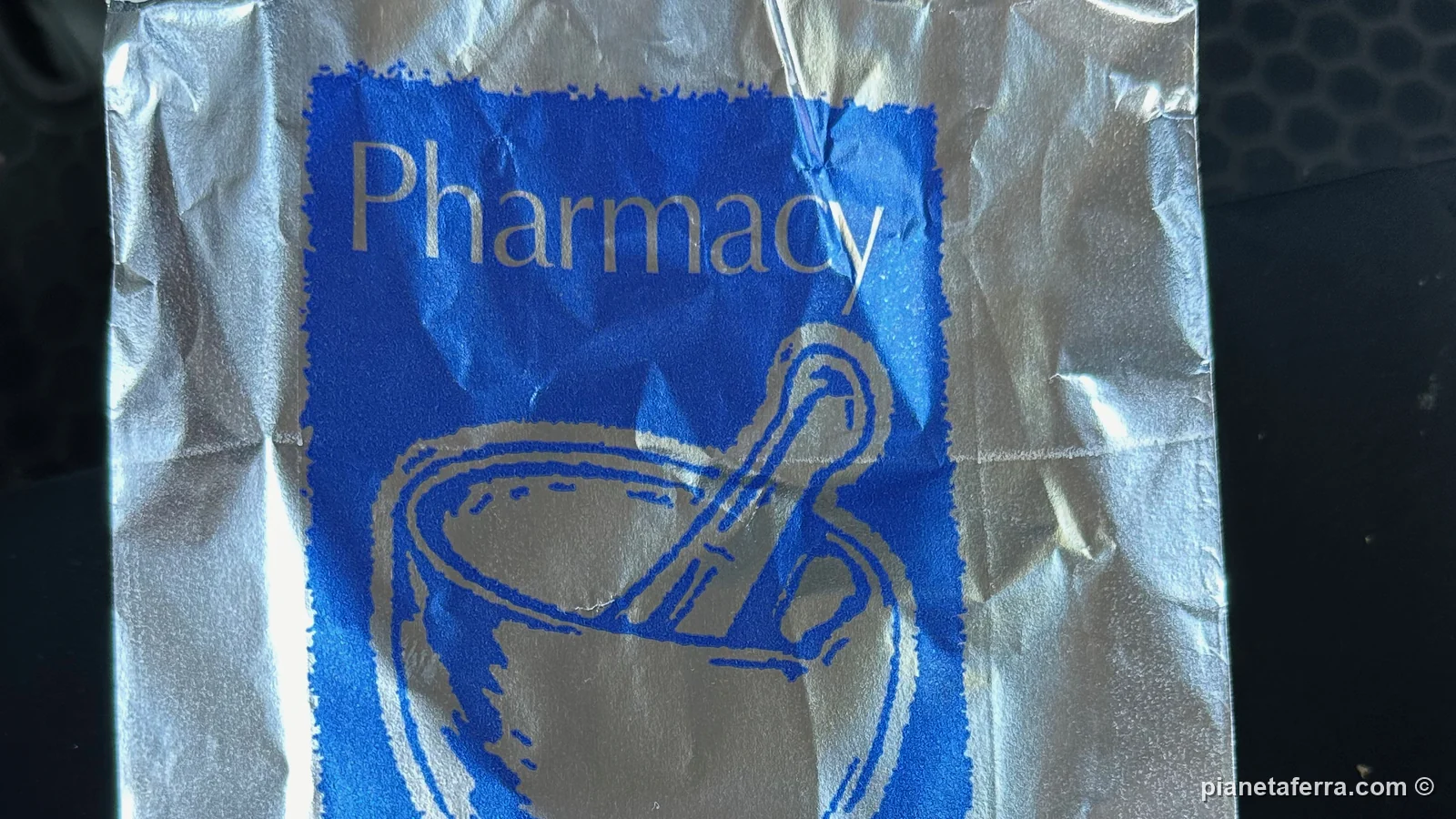 Il sacchetto di carta di una farmacia all'estero, con la scritta Pharmacy e il disegno di un mortaio