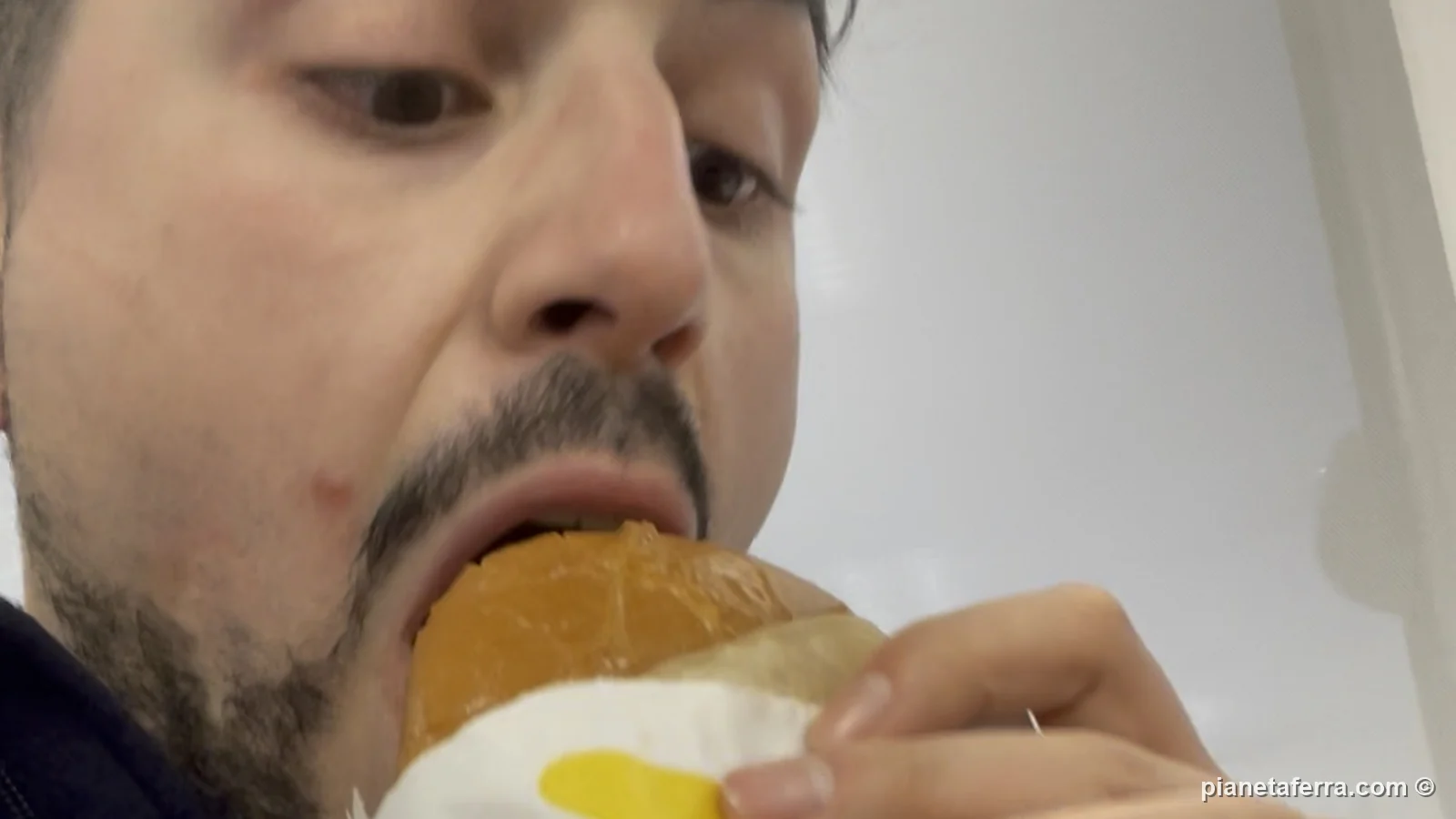 Luca Ferraina mentre mangia un hamburger all'In-N-Out di Bakersfield, a febbraio 2022