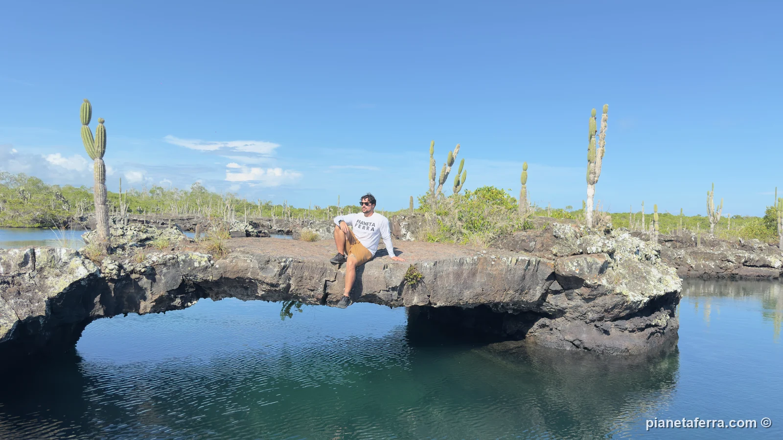 Luca seduto su un arco di lava a Los Túneles, a Isabela, con il cielo limpido, ad aprile 2026