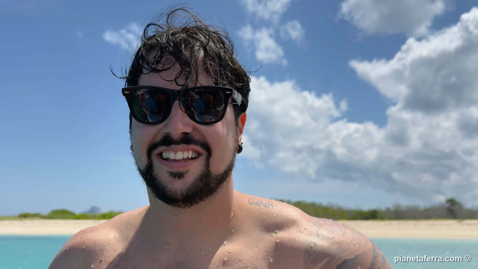 Luca al sole in barca davanti a una spiaggia di San Cristóbal, a fine marzo 2026