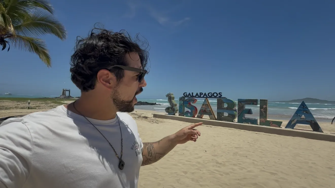 Luca davanti alla scritta Galápagos Isabela sulla spiaggia di Puerto Villamil