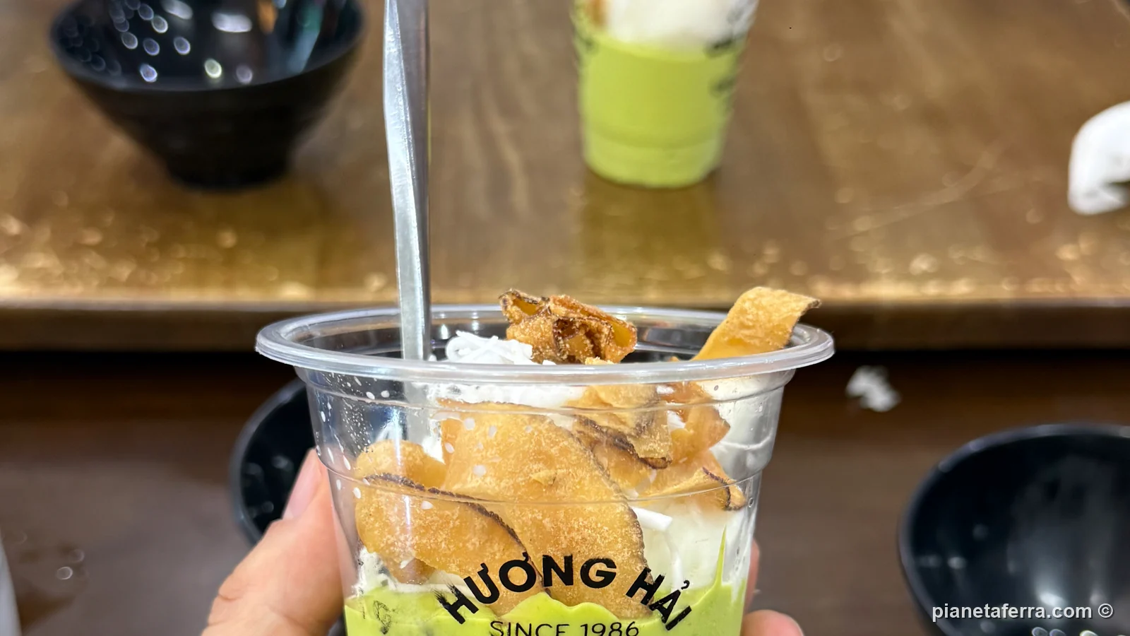 La coppa del kem bơ di Chè Hương Hải con il gelato al cocco e le scaglie di cocco tostato sopra la crema di avocado