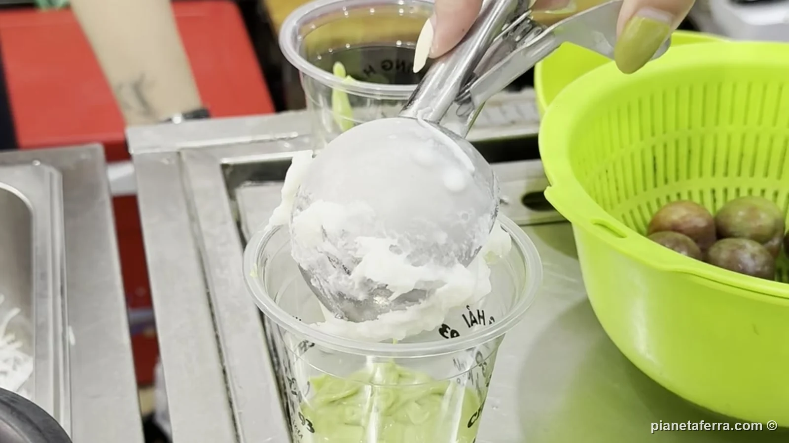 La pallina di gelato al cocco appoggiata sopra la crema di avocado ghiacciata nel bicchiere del kem bơ, da Chè Hương Hải ad Hanoi