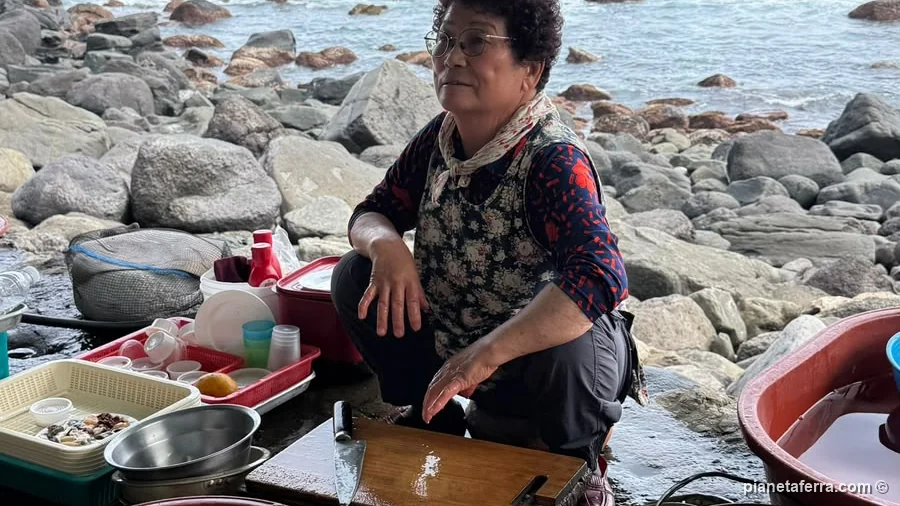 Una haenyeo di Jeju al bulteok con il pescato del giorno