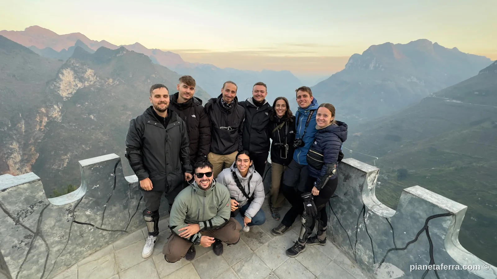 Gruppo di backpacker al tramonto su una terrazza panoramica durante il Ha Giang Loop, nel nord del Vietnam