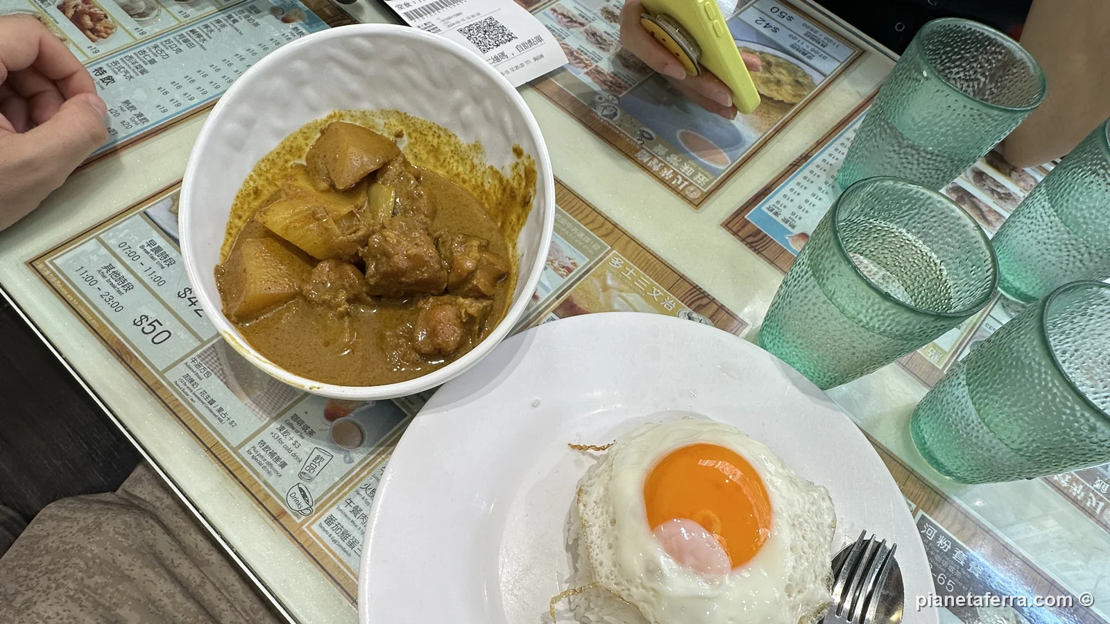 Il pranzo in un cha chaan teng di Mong Kok, con curry e uovo fritto, a Hong Kong, a maggio 2024