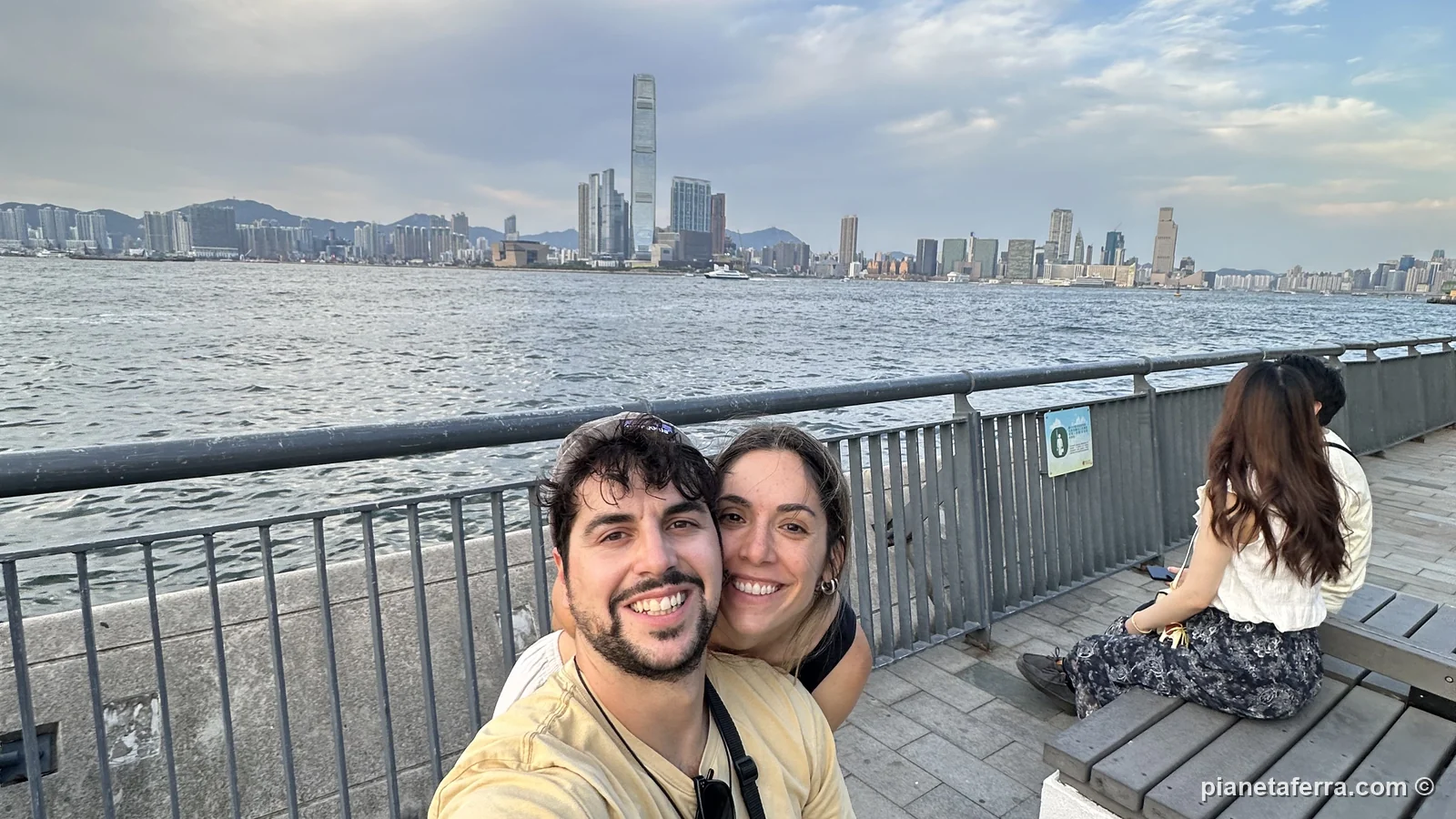 Luca e Patricia sul lungomare di Sai Ying Pun al tramonto, con Kowloon sullo sfondo, a Hong Kong, a maggio 2024