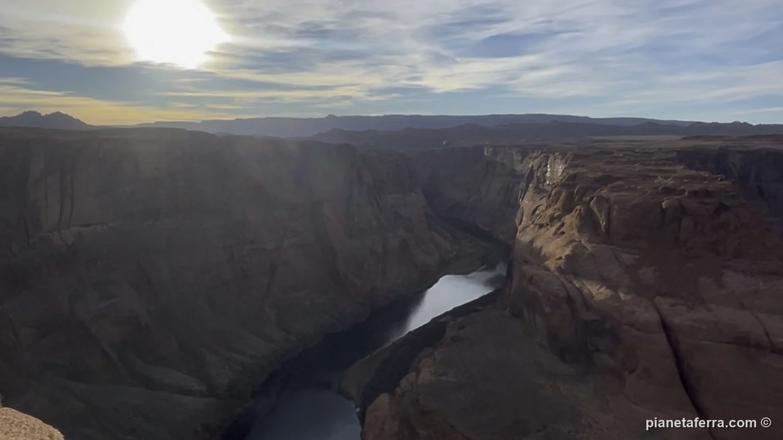 Il sole che tramonta dietro l'ansa di Horseshoe Bend, con il fiume in ombra, a febbraio 2022