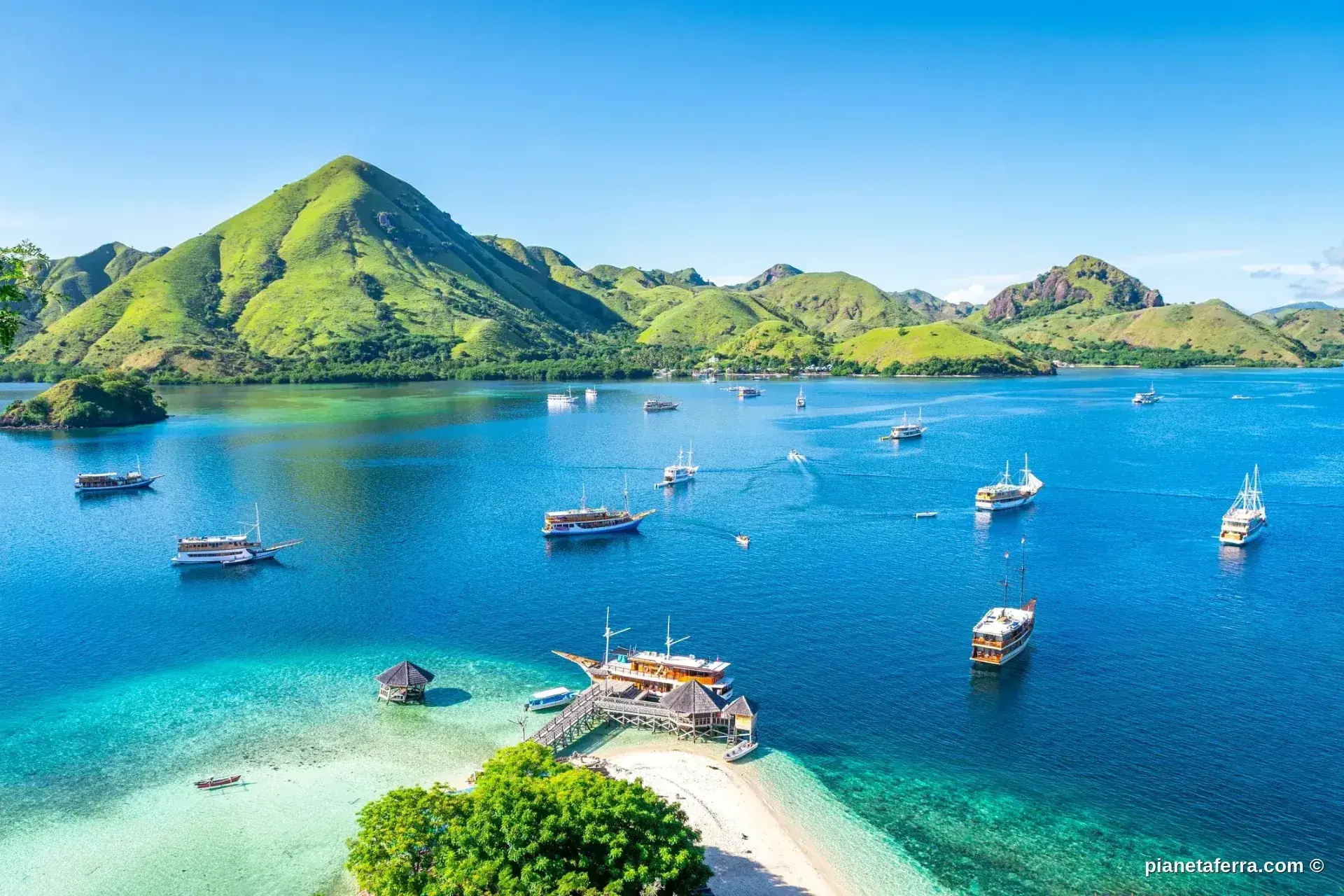 Barche nel mare turchese di Komodo in Indonesia con isole verdi
