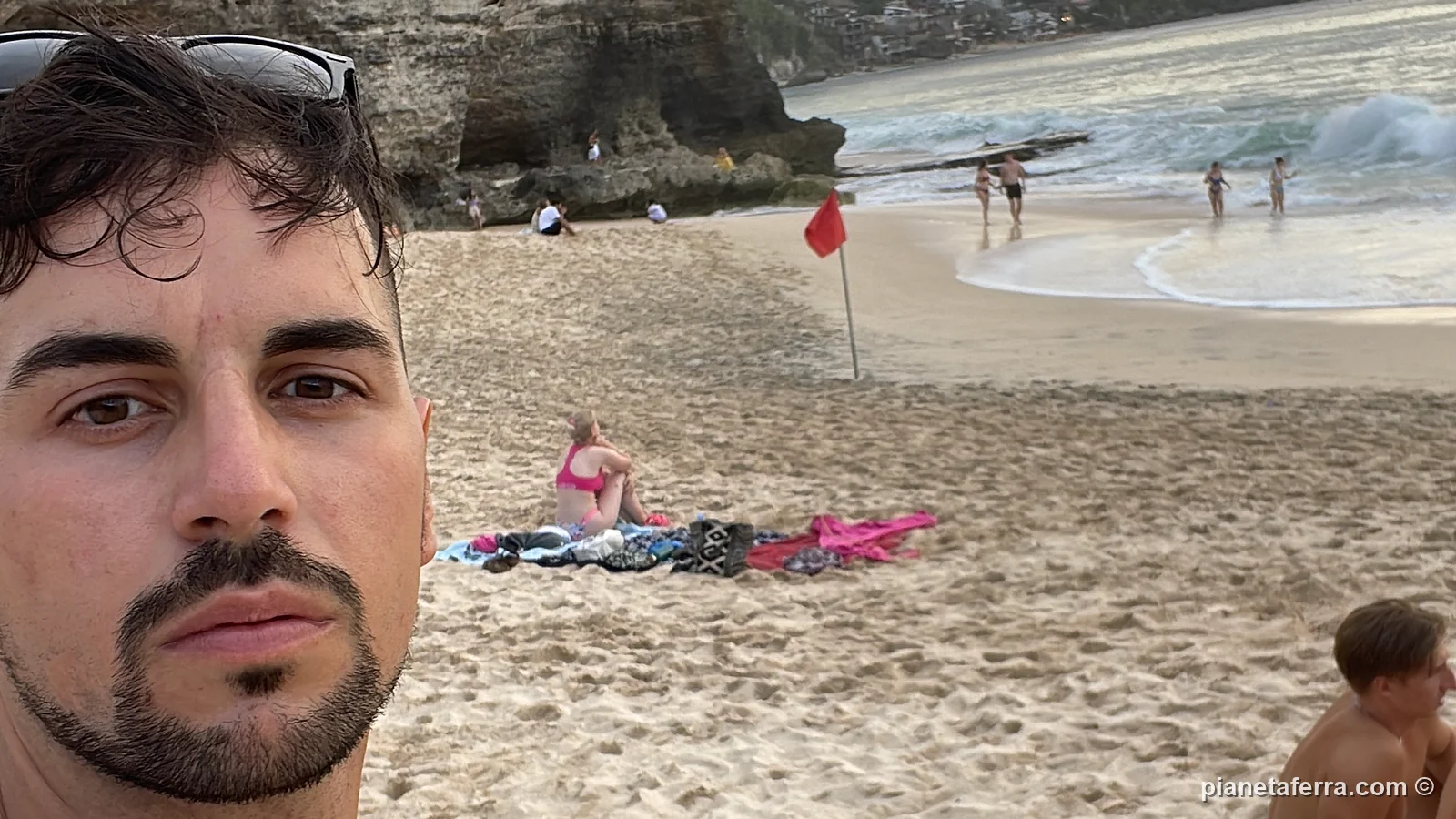 Luca in spiaggia con la scogliera alle spalle