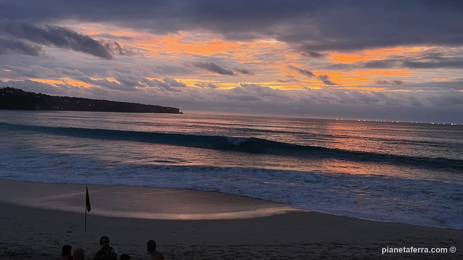 Il tramonto sul mare dalla spiaggia sotto le scogliere del Bukit, al sud di Bali