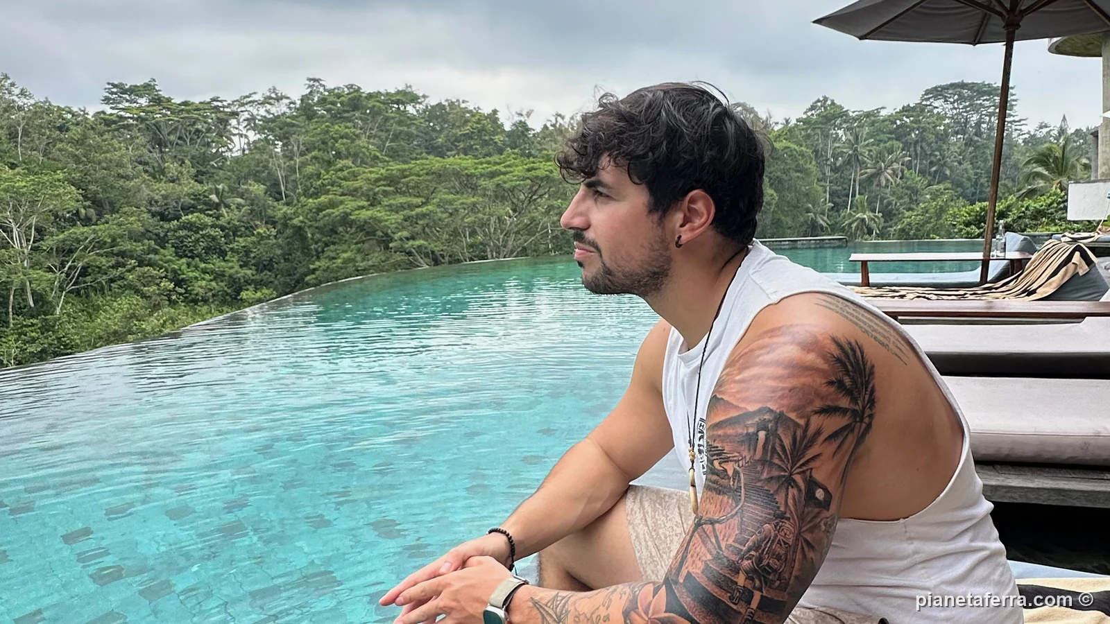 Luca nella piscina a sfioro sulla giungla intorno a Ubud