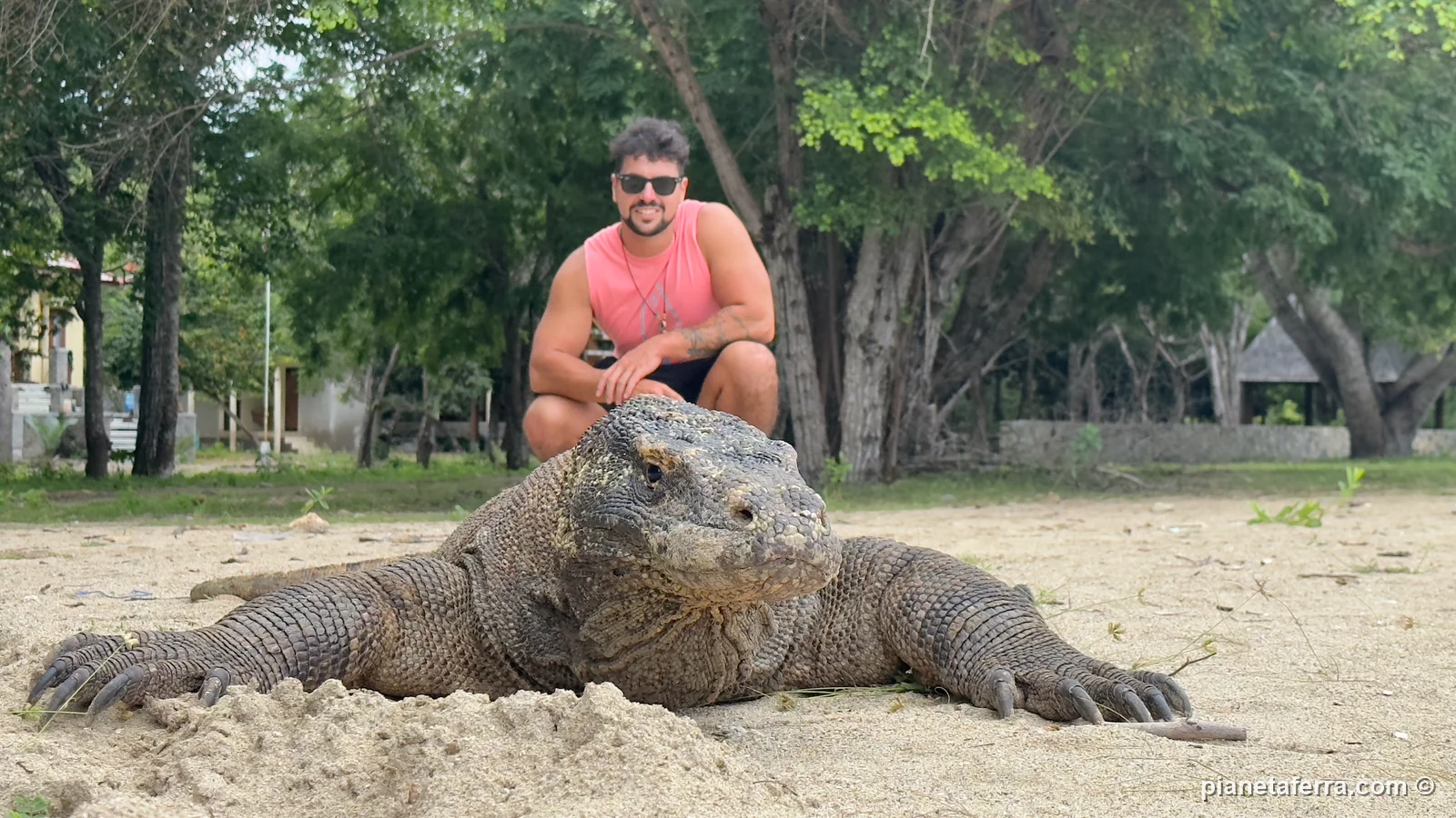 Luca accovacciato vicino a un drago di Komodo sull'isola di Komodo, accompagnato dal ranger