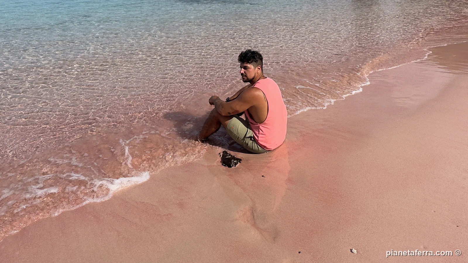 Luca seduto sulla sabbia rosa della Pink Beach nel Parco Nazionale di Komodo