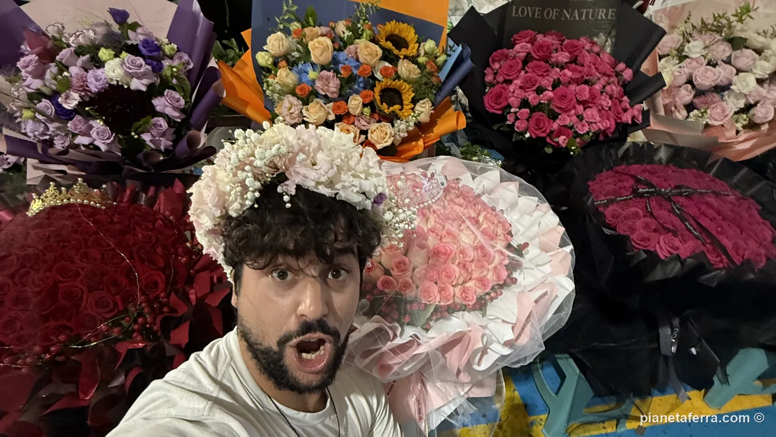 Luca con una corona di fiori in testa tra i banchi del mercato di Dounan, a Kunming