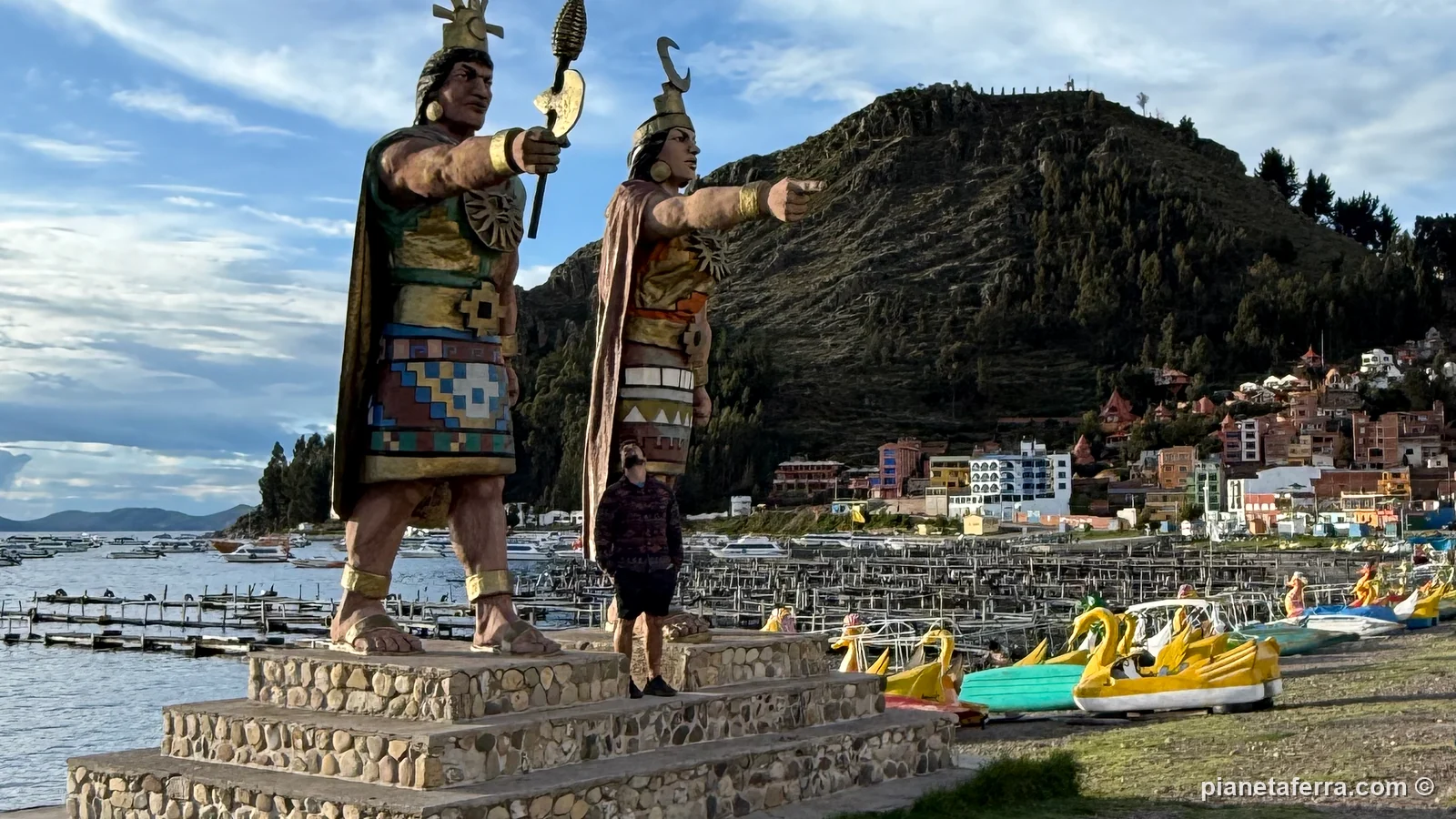 Le statue inca sul lungolago di Copacabana, con le barche a forma di cigno e il Cerro Calvario sullo sfondo