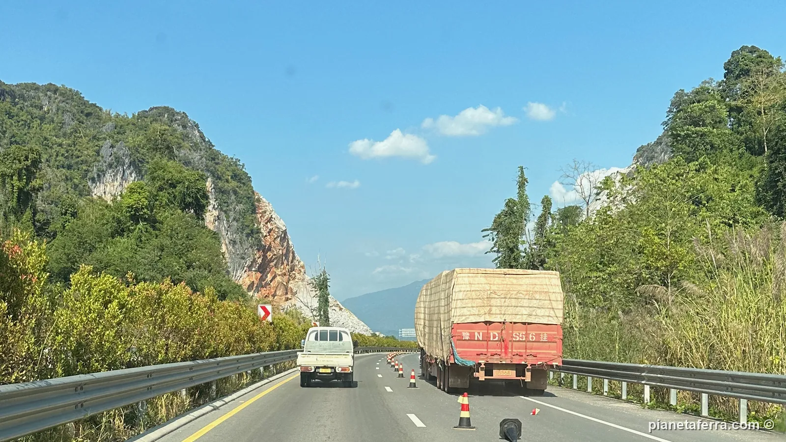 L'autostrada tra Vientiane e Vang Vieng tra le montagne carsiche, con un camion carico