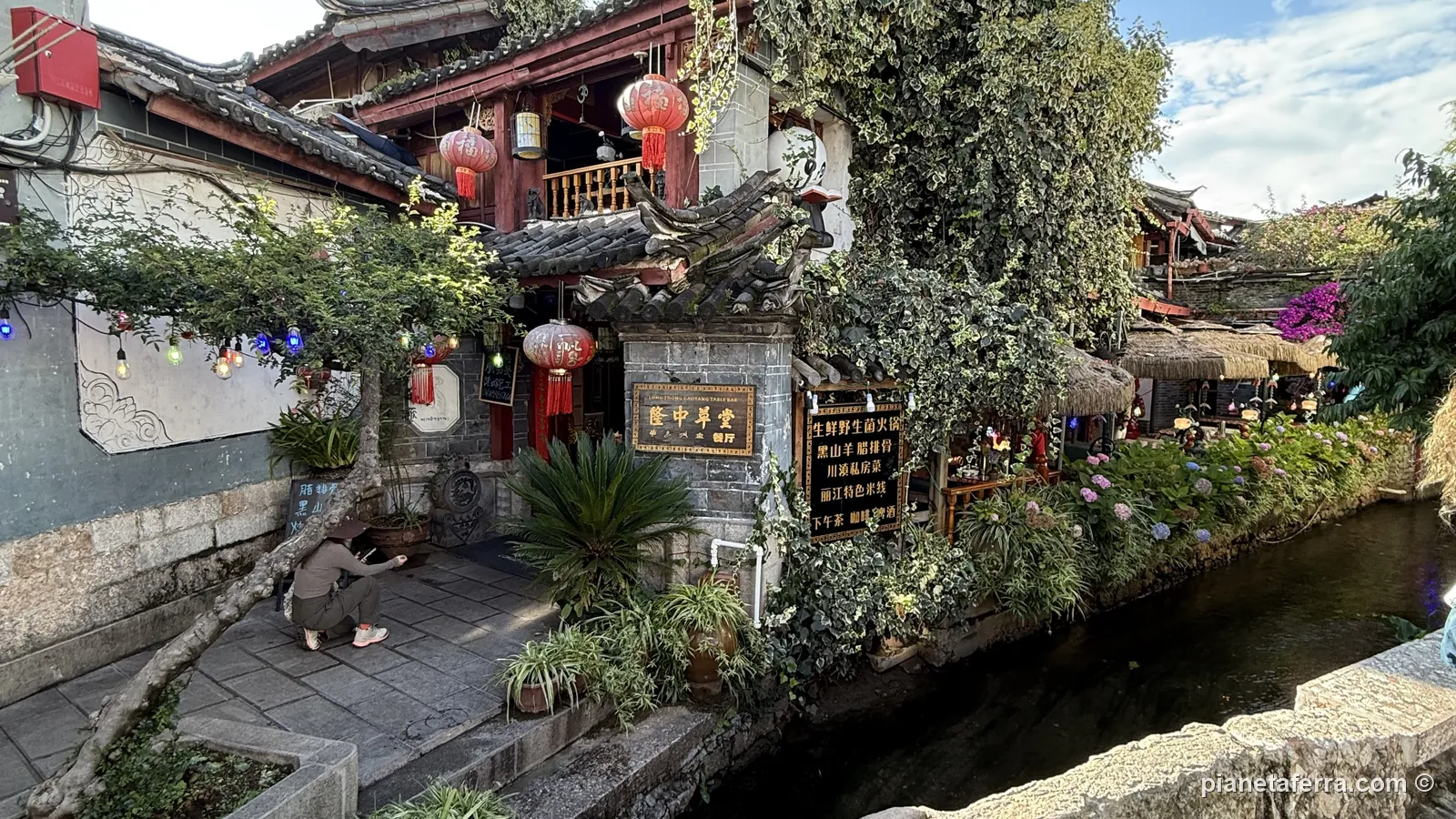 Un canale della città vecchia di Lijiang, tra le case e le lanterne rosse