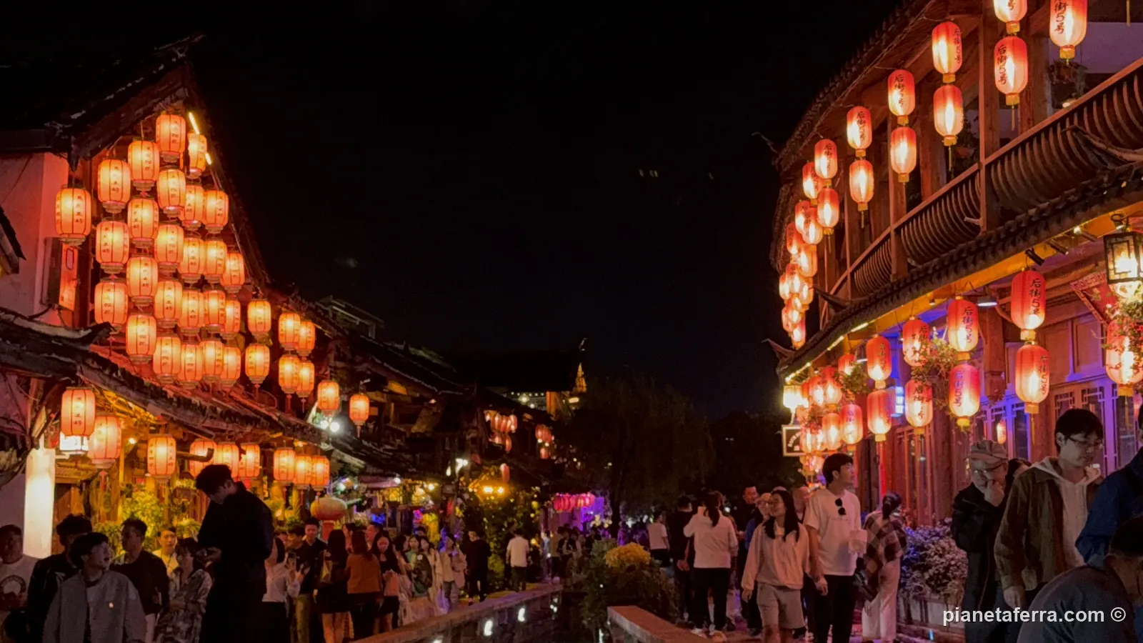 La sera nella città vecchia di Lijiang, con le lanterne rosse accese e la folla tra i locali