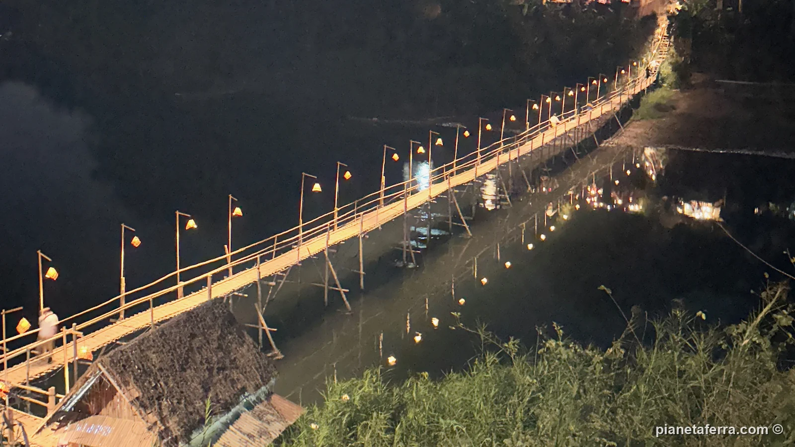 Il ponte di bambù sul fiume Nam Khan illuminato la sera a Luang Prabang