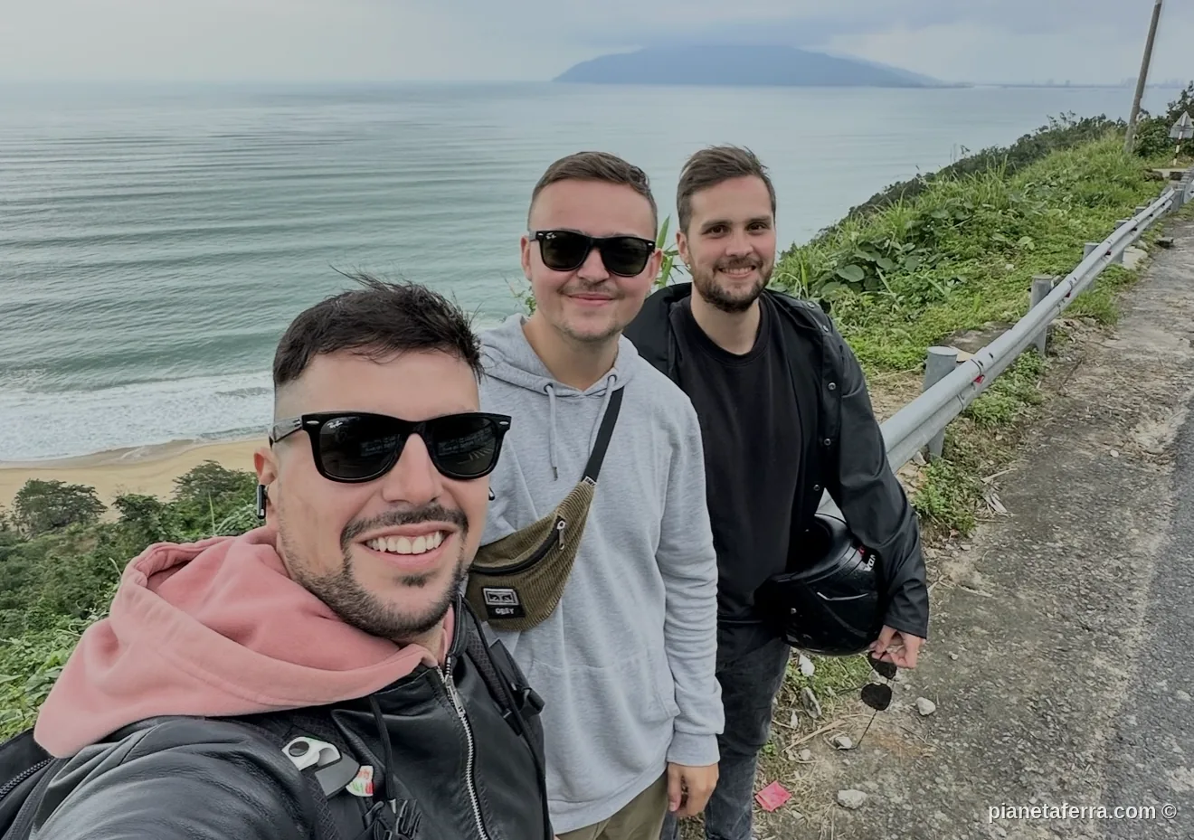 Selfie di tre viaggiatori sulla strada costiera dell'Hai Van Pass in Vietnam poco prima dell'acquazzone