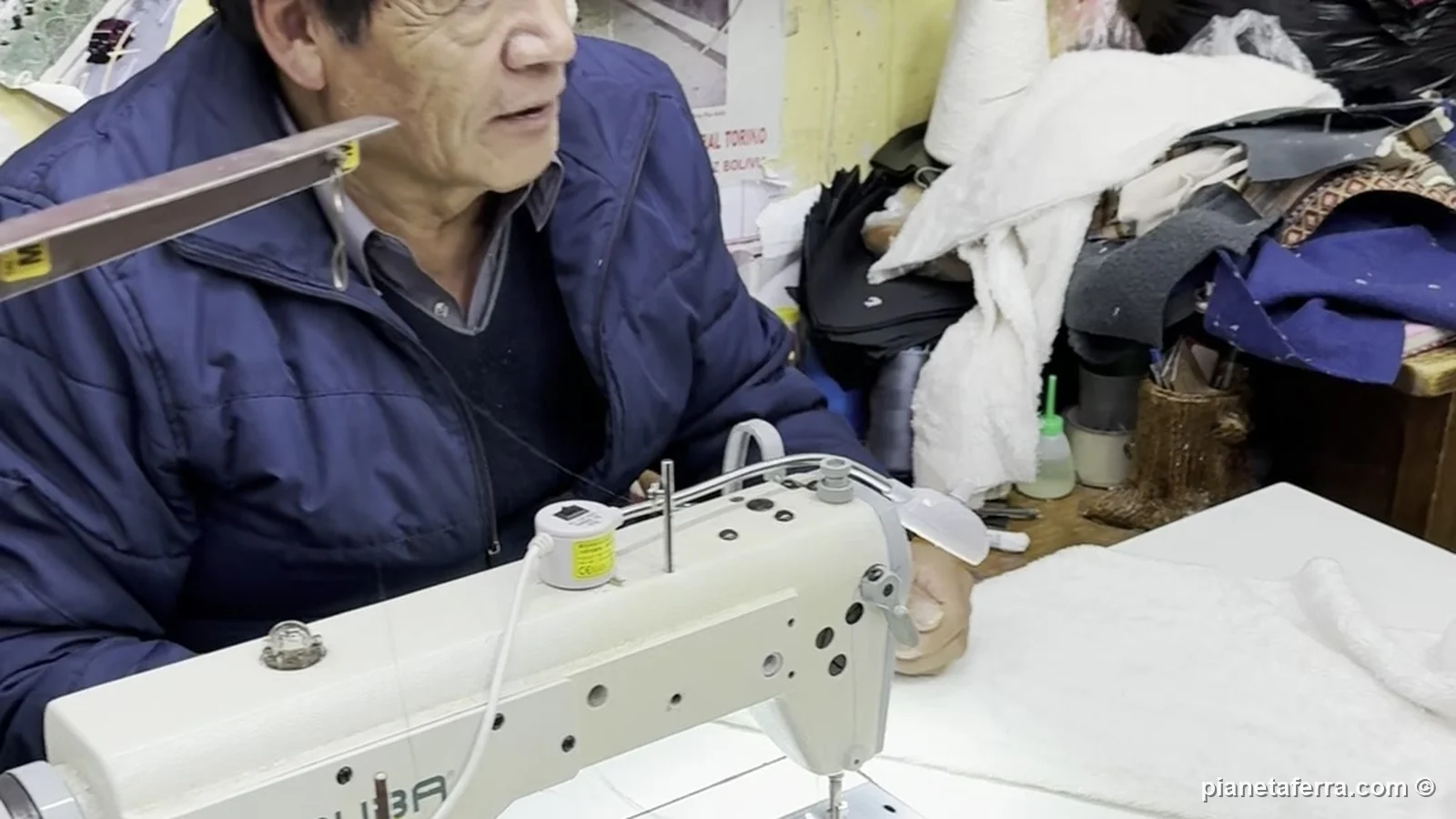 Il sarto alla macchina da cucire in un laboratorio di calle Sagárnaga, dove i pile con l'aguayo vengono cuciti su misura