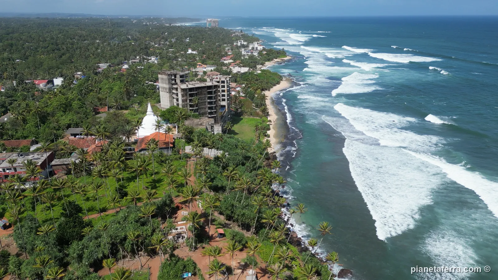 La costa sud dello Sri Lanka vista dall'alto vicino a Mirissa, con il tempio bianco e le onde del monsone, a giugno 2024