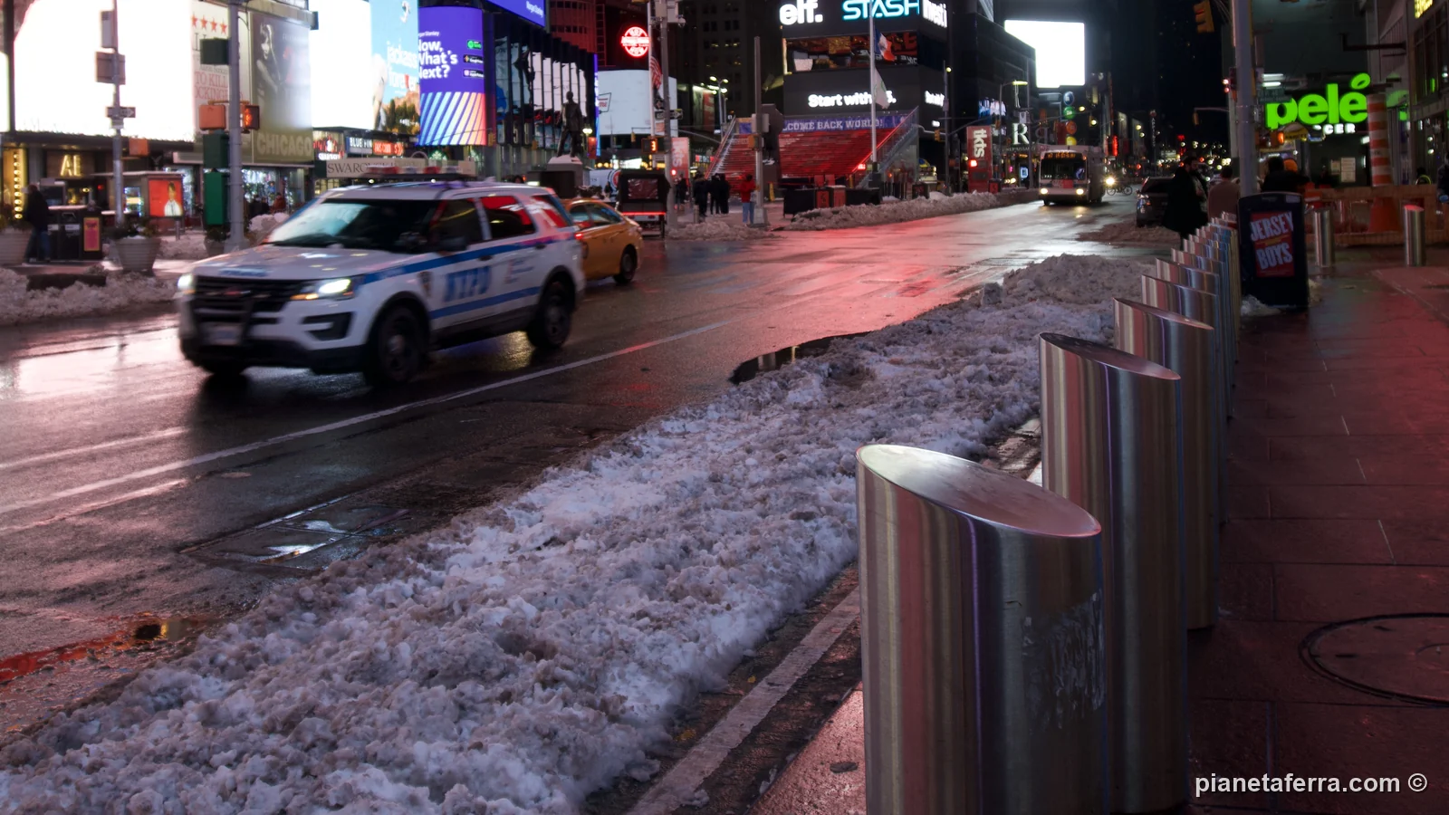 Times Square di notte con la neve accumulata ai lati della strada, a gennaio 2022