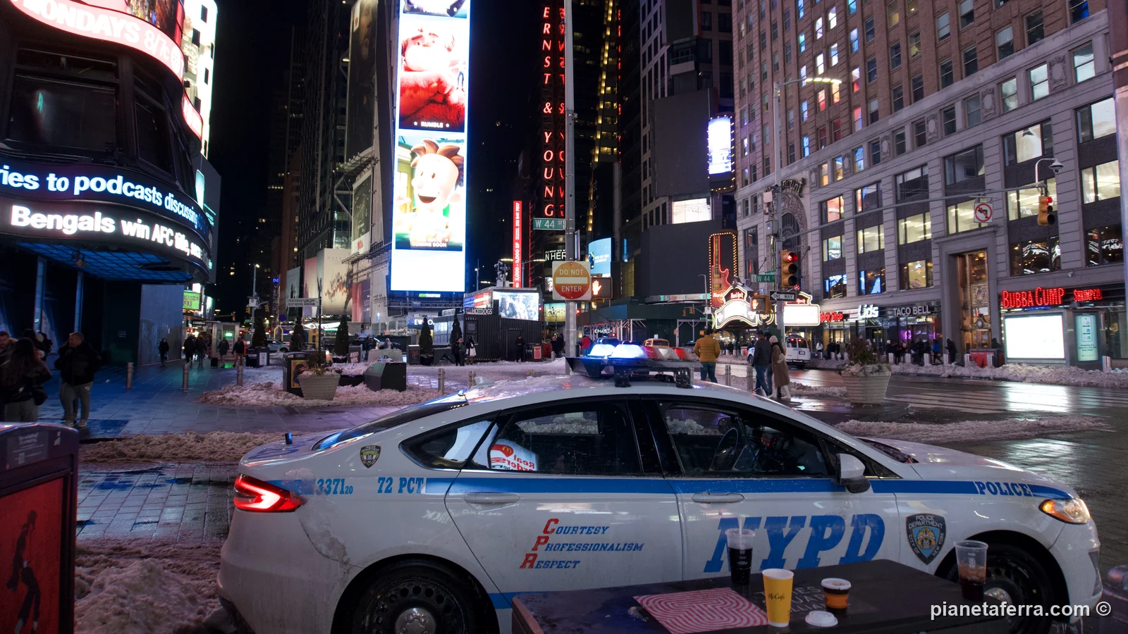 Times Square di notte con la neve e un'auto della polizia di New York, a gennaio 2022