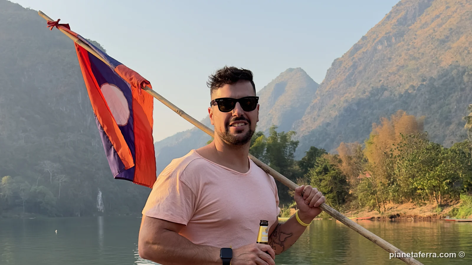 Luca con la bandiera del Laos su una barca sul fiume Nam Ou a Nong Khiaw