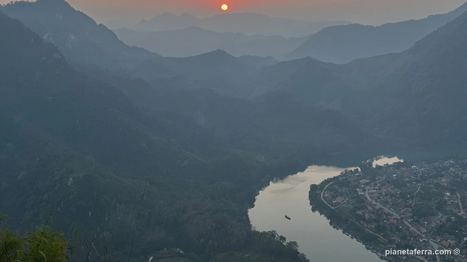 Il tramonto dal viewpoint sopra Nong Khiaw, con il fiume Nam Ou e il villaggio nella valle
